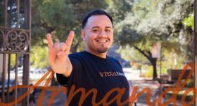 Graduate student holding up hook'em hand signal