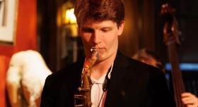 A person plays a saxophone.
