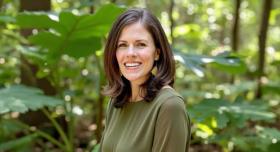 Amy Patten poses in front of a forest background.