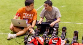 PhD students Dongmyeong Lee and Zifan Xu prepare their child-sized humanoid robots before a match at RoboCup 2025 in Salvador, Brazil.