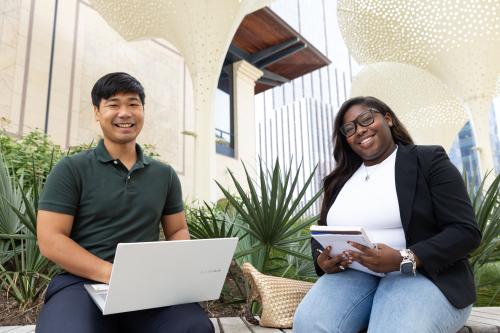 two students on patio smiling