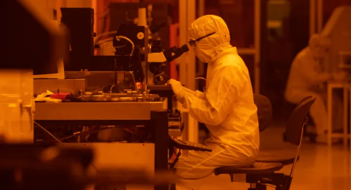 Frances Camille Wu, a graduate research assistant in the Microelectronics Research Center, uses a microscope to study electronic devices in a clean room at the Pickle Research Campus in Austin, Texas.