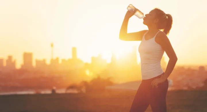 Woman drinking water in the hot sun.