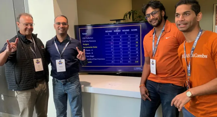 Members of the Texas McCombs team gather around the scoreboard showing their big lead after three rounds at the UC Davis-Financial Times Biz Quiz last fall. They are, from left, team coach Joe Hahn, associate dean for McCombs graduate programs, and MBA students Sunny Sharma, Karan Kanatala, and Soham Mukherjee.
