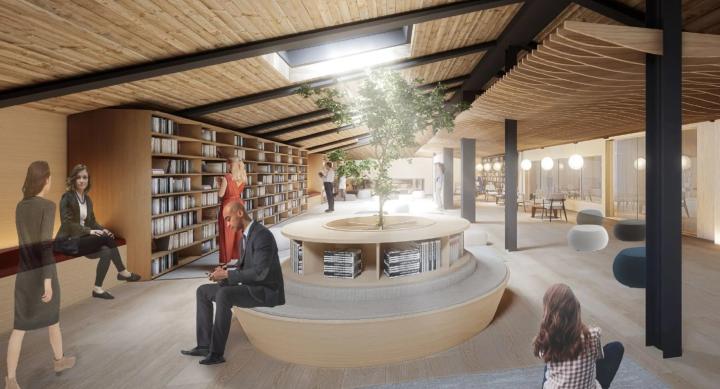 People in businesswear explore a building with wood ceilings.