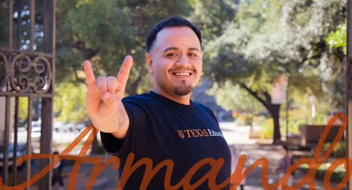Graduate student holding up hook'em hand signal