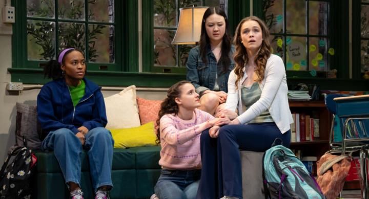 Four theatre performers pose on a high school set.