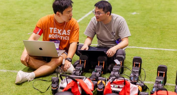 PhD students Dongmyeong Lee and Zifan Xu prepare their child-sized humanoid robots before a match at RoboCup 2025 in Salvador, Brazil.